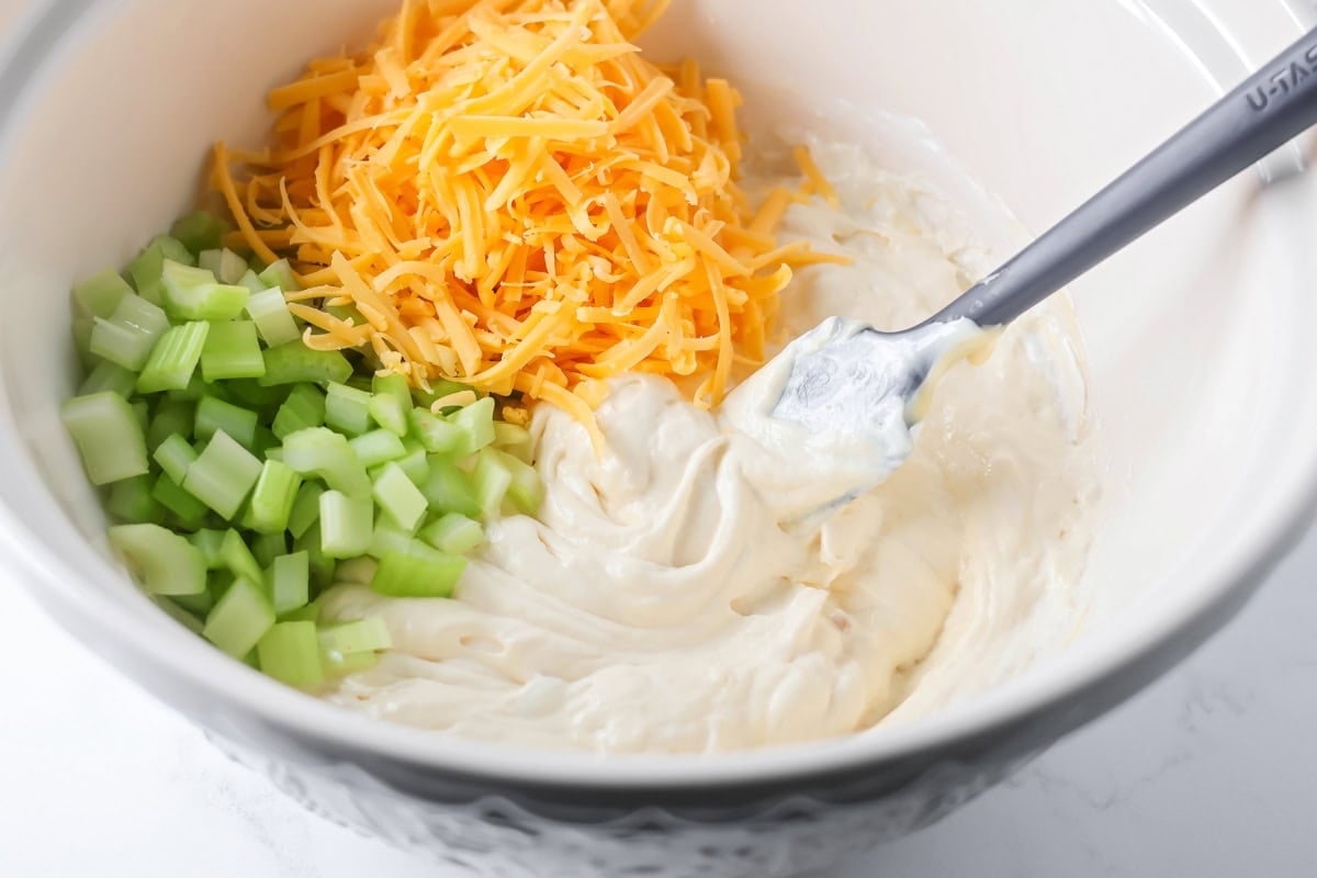 Mayo, celery, and seasonings in a bowl for french onion chicken casserole.