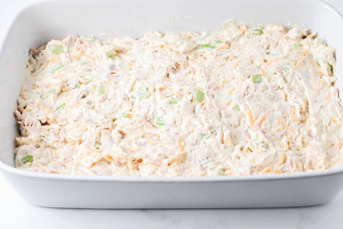 A casserole dish filled with french onion chicken casserole ready to be baked.