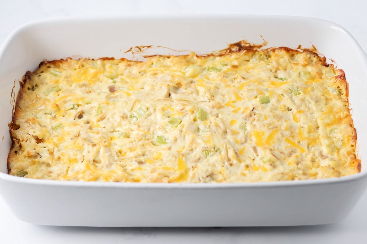 Spreading the filling in a baking dish for french onion chicken casserole.