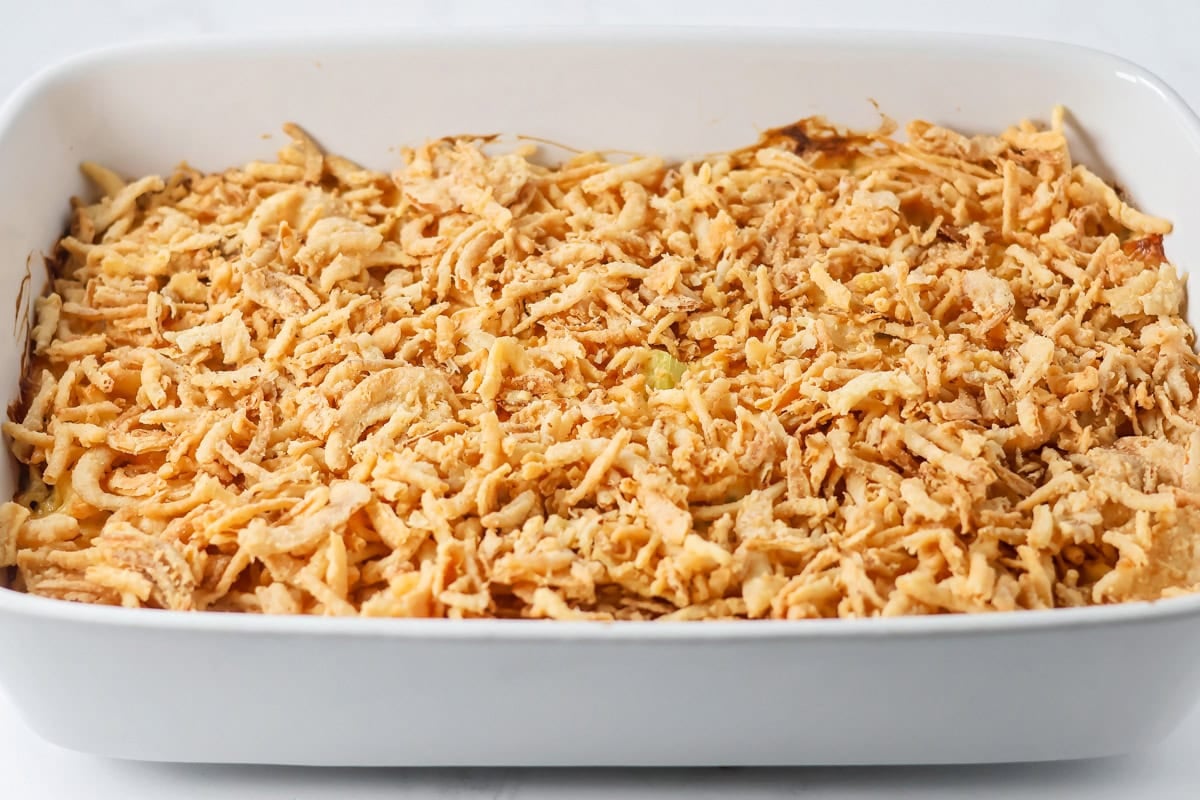 A white casserole dish filled with french onion chicken casserole.