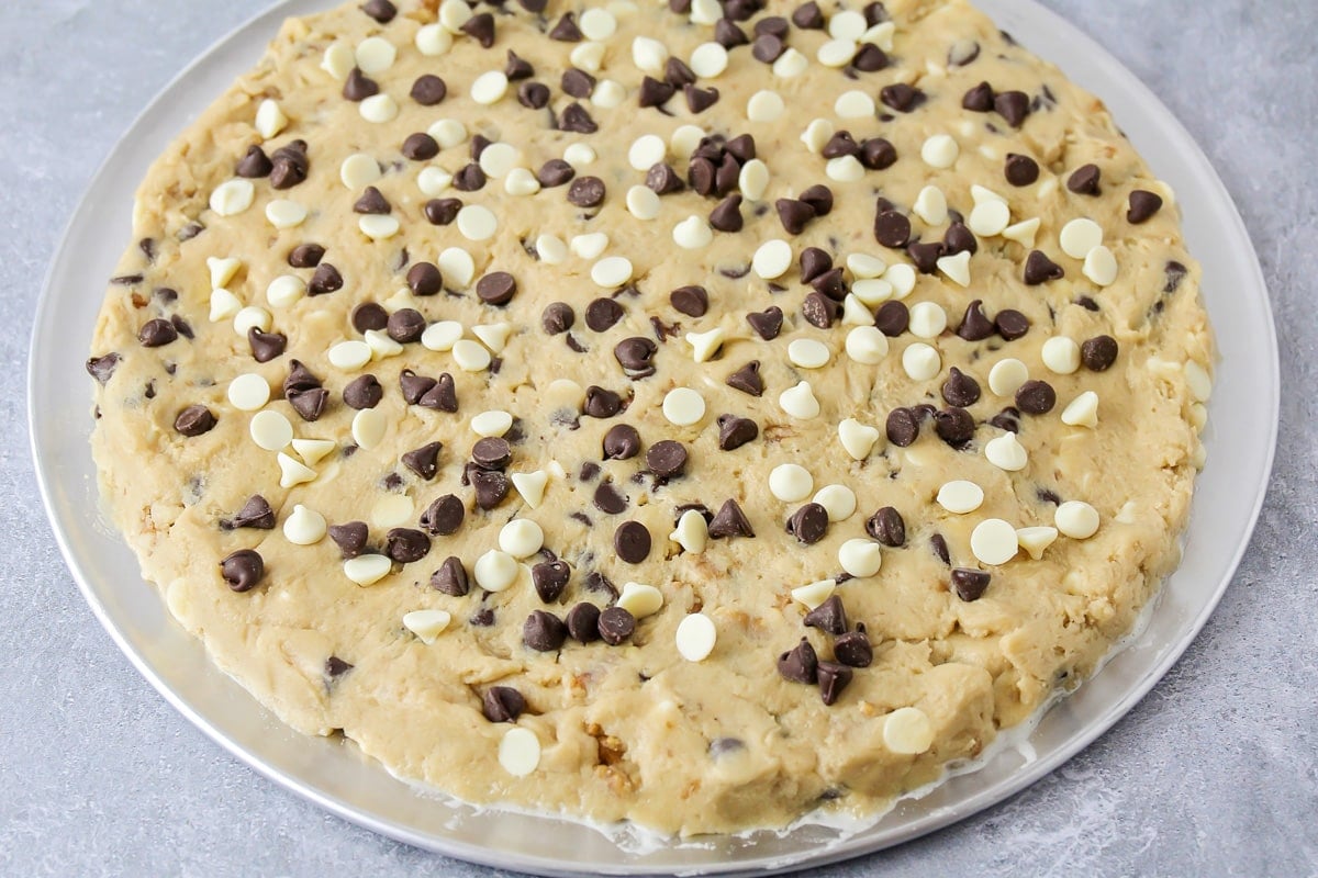 giant chocolate chip cookie dough on a pizza pan