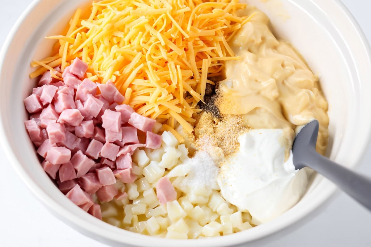 Ham and potato casserole ingredients in bowl.