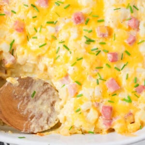 Ham and potato casserole in baking dish with scoop dished out.
