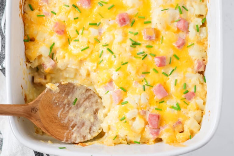 Ham and potato casserole in baking dish with scoop dished out.