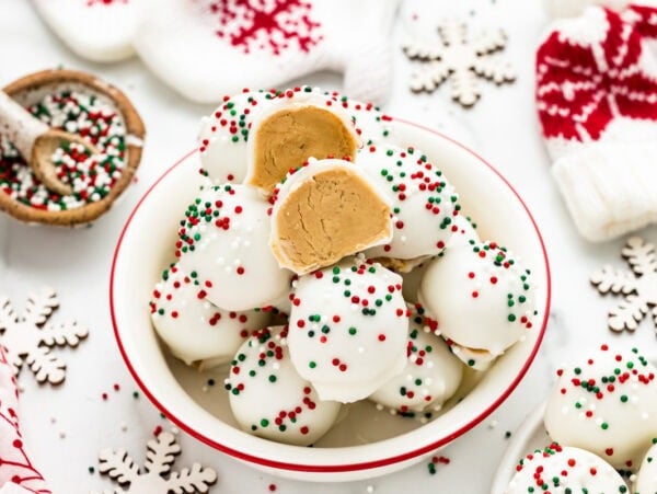 A bowl of peanut butter snowballs with one cut in half.
