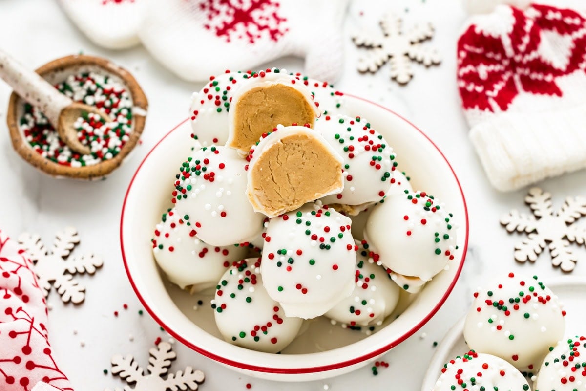 A bowl of peanut butter snowballs with one cut in half.