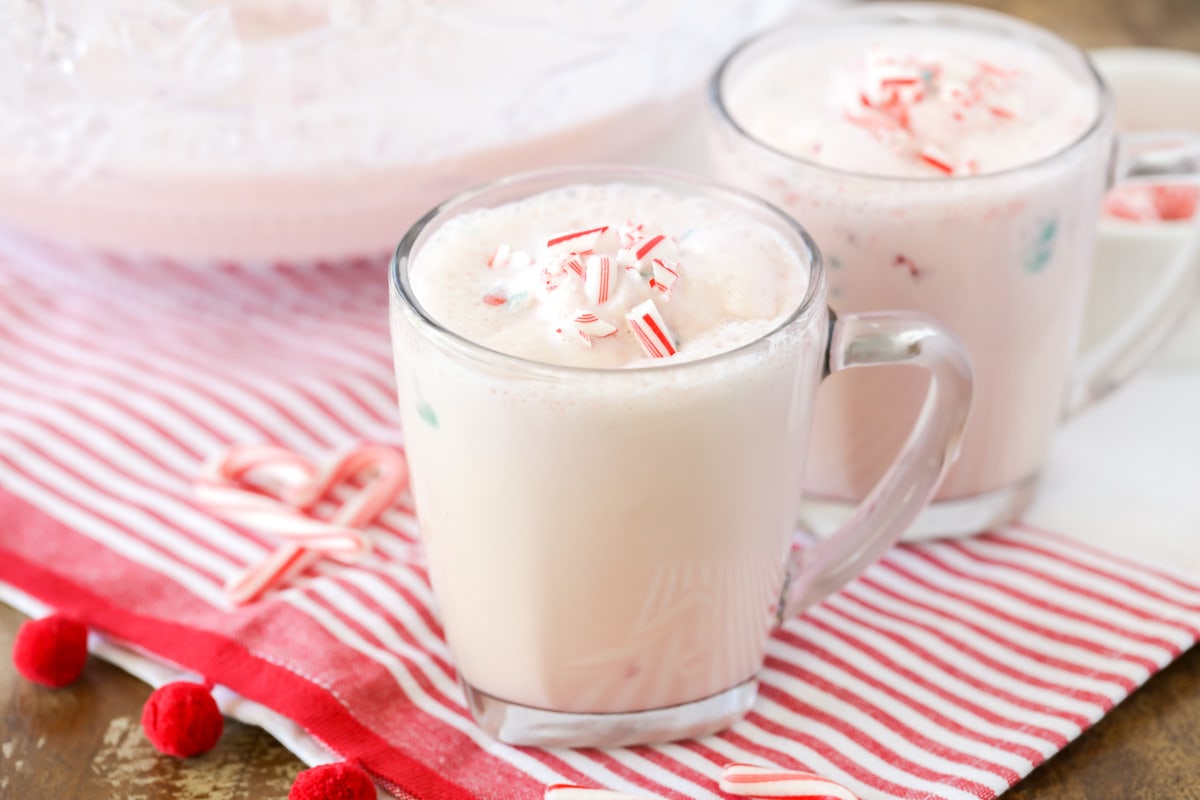 Peppermint Punch topped with crushed candy canes in a glass mug