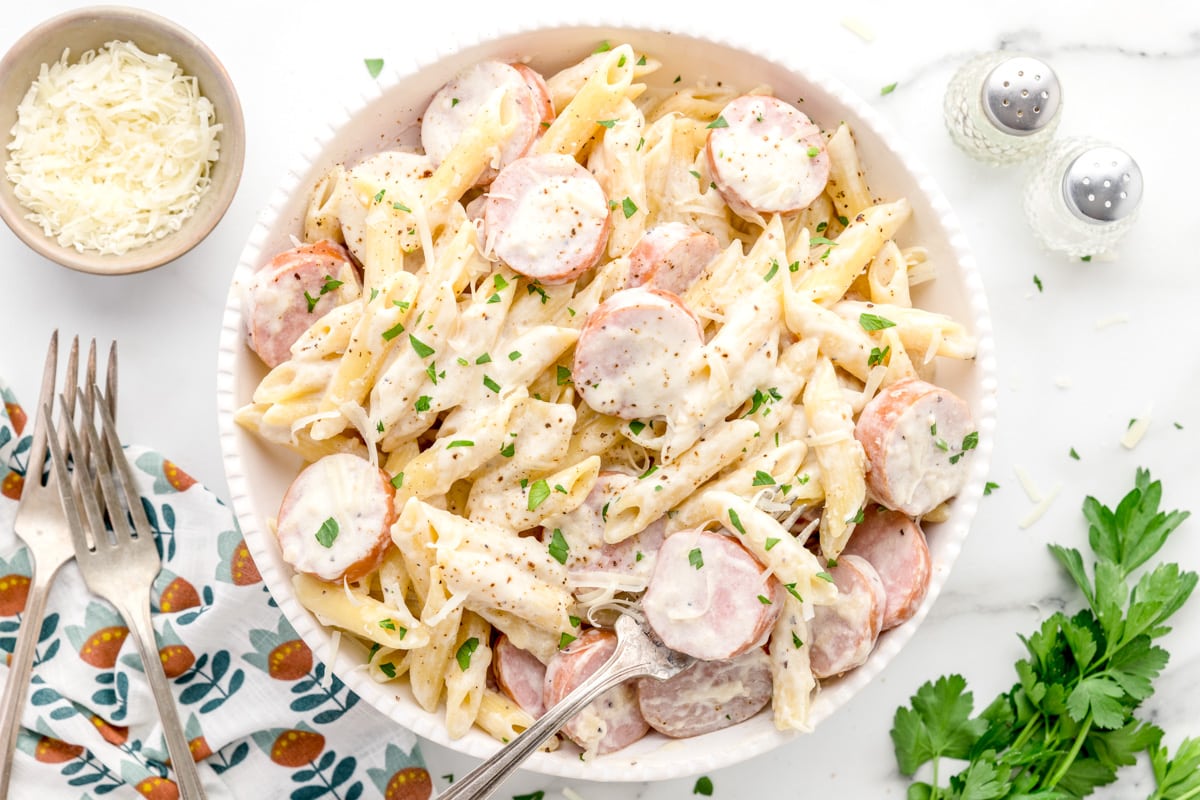 Peppered sausage alfredo served in a white bowl