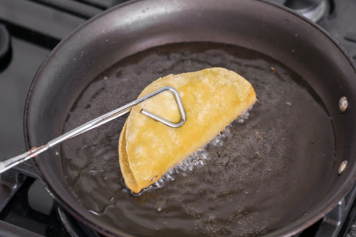 Frying tacos in oil.