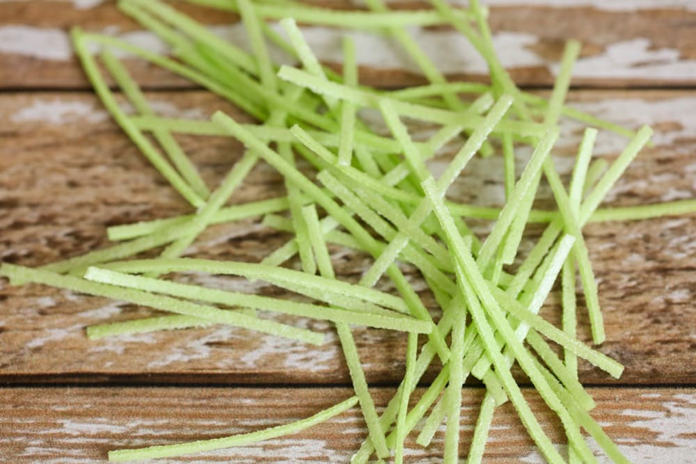 Edible grass spread out on a wood surface.