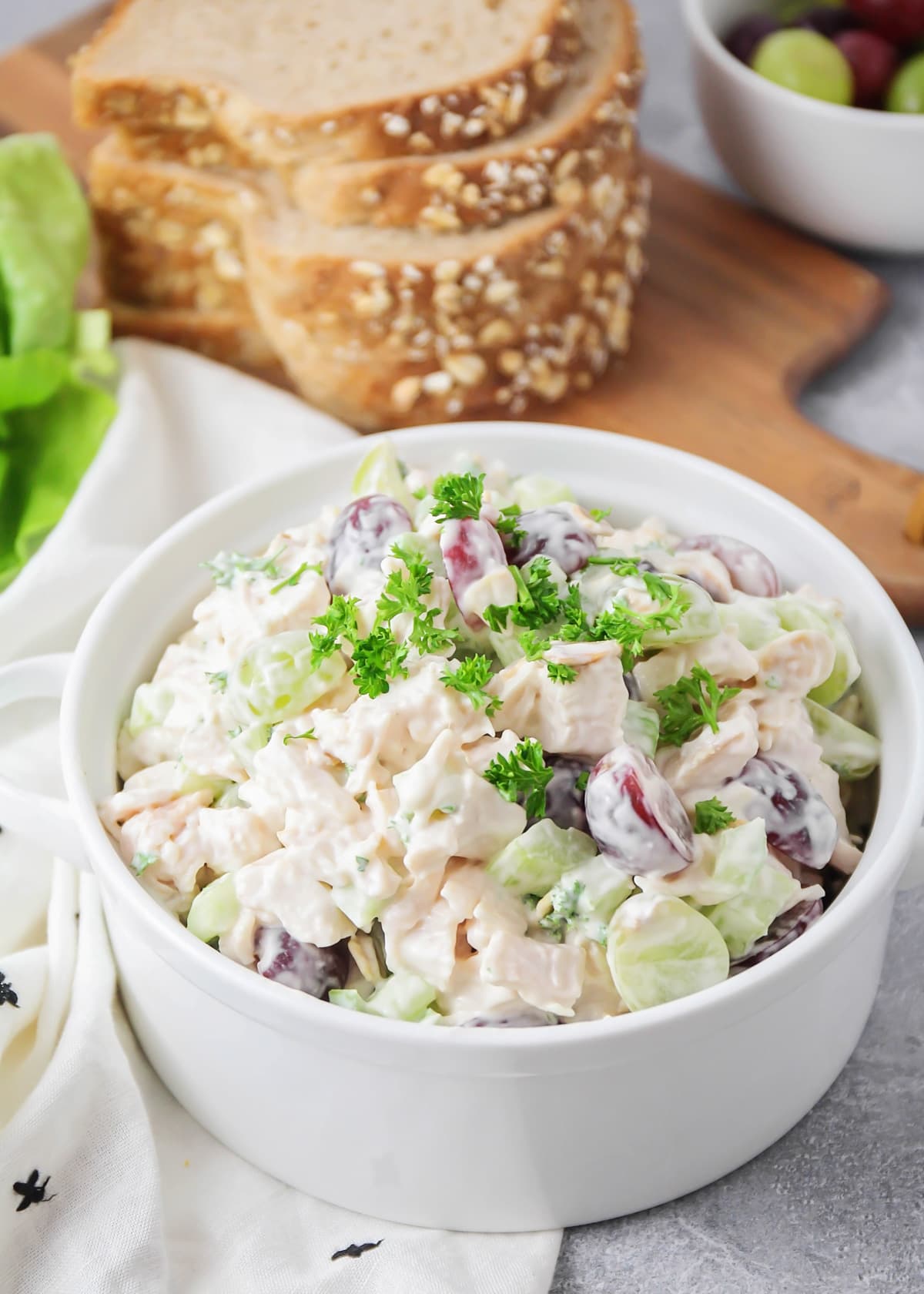 Chicken salad with grapes in a white bowl.