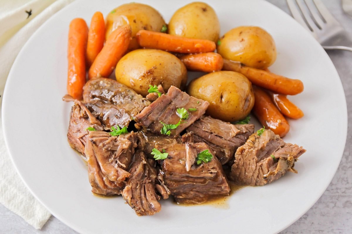 Close up image of pot roast recipe with carrots and potatoes.