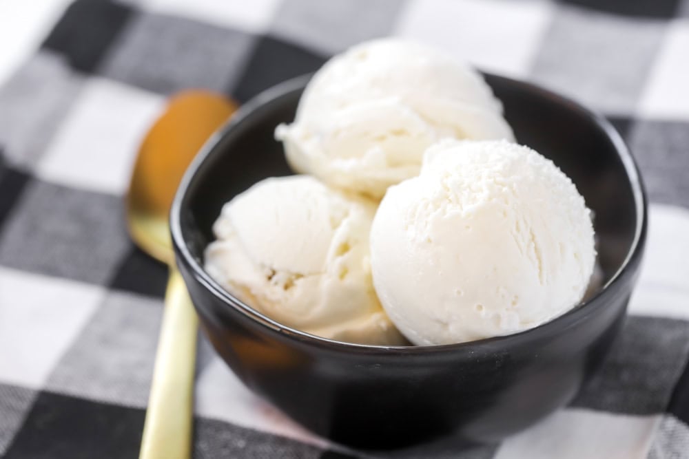 A black bowl of vanilla ice cream.