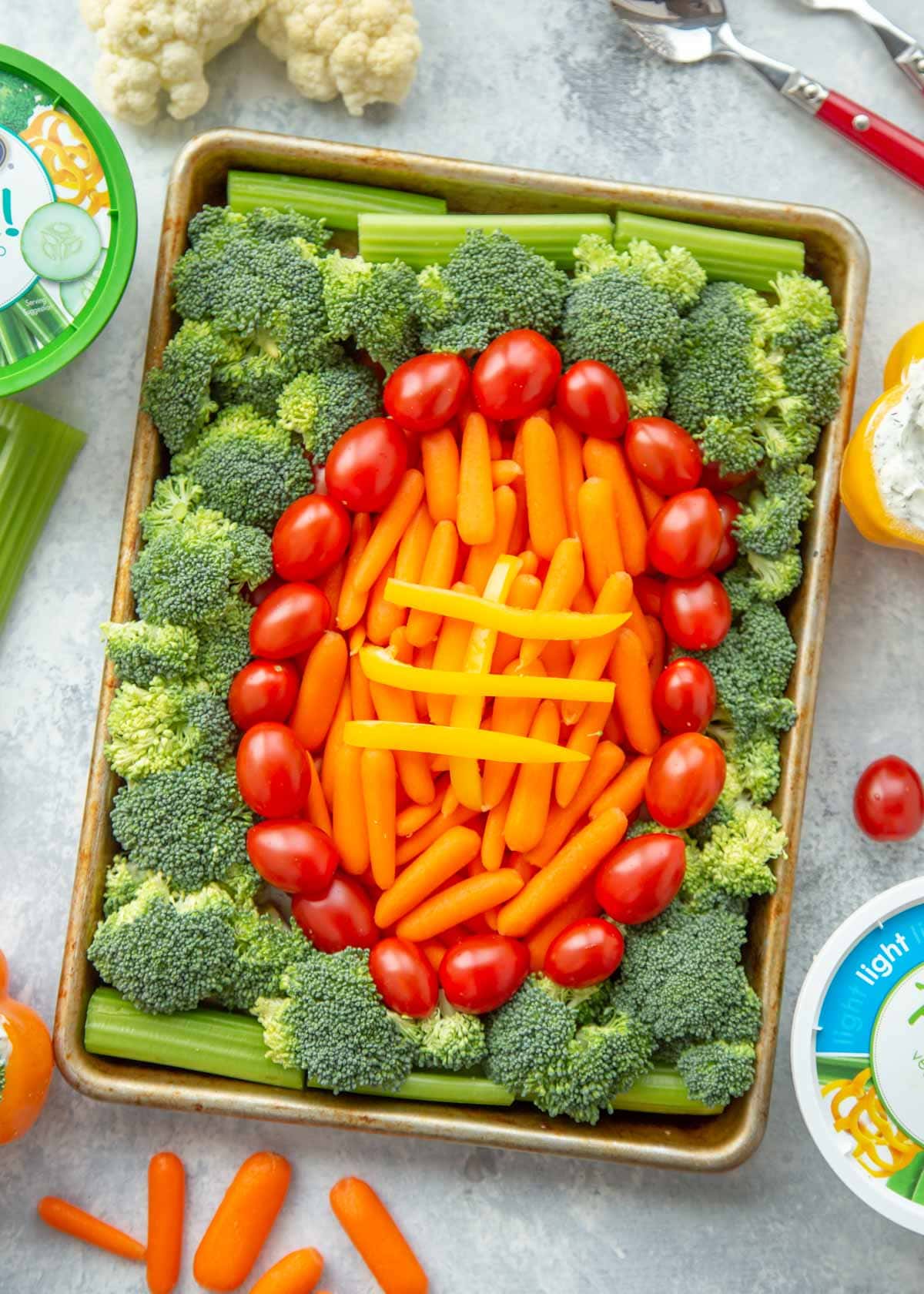 Football shaped veggie tray served on a sheet pan.