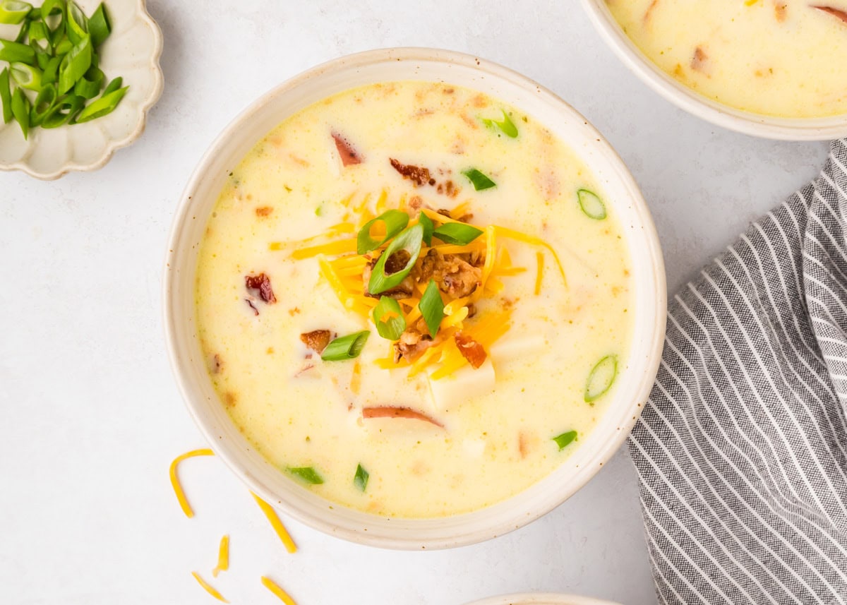 Crock pot baked potato soup in a white bowl.