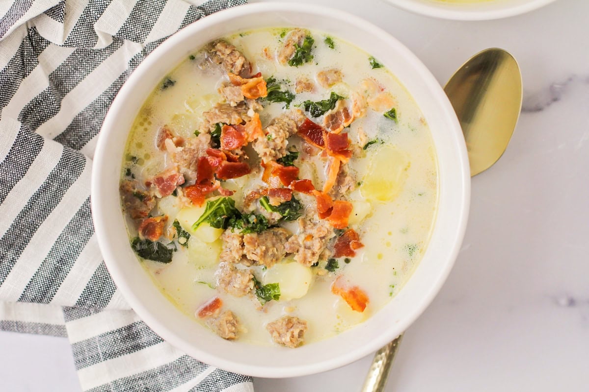 Zuppa Toscana recipe in white bowl with gold spoon.