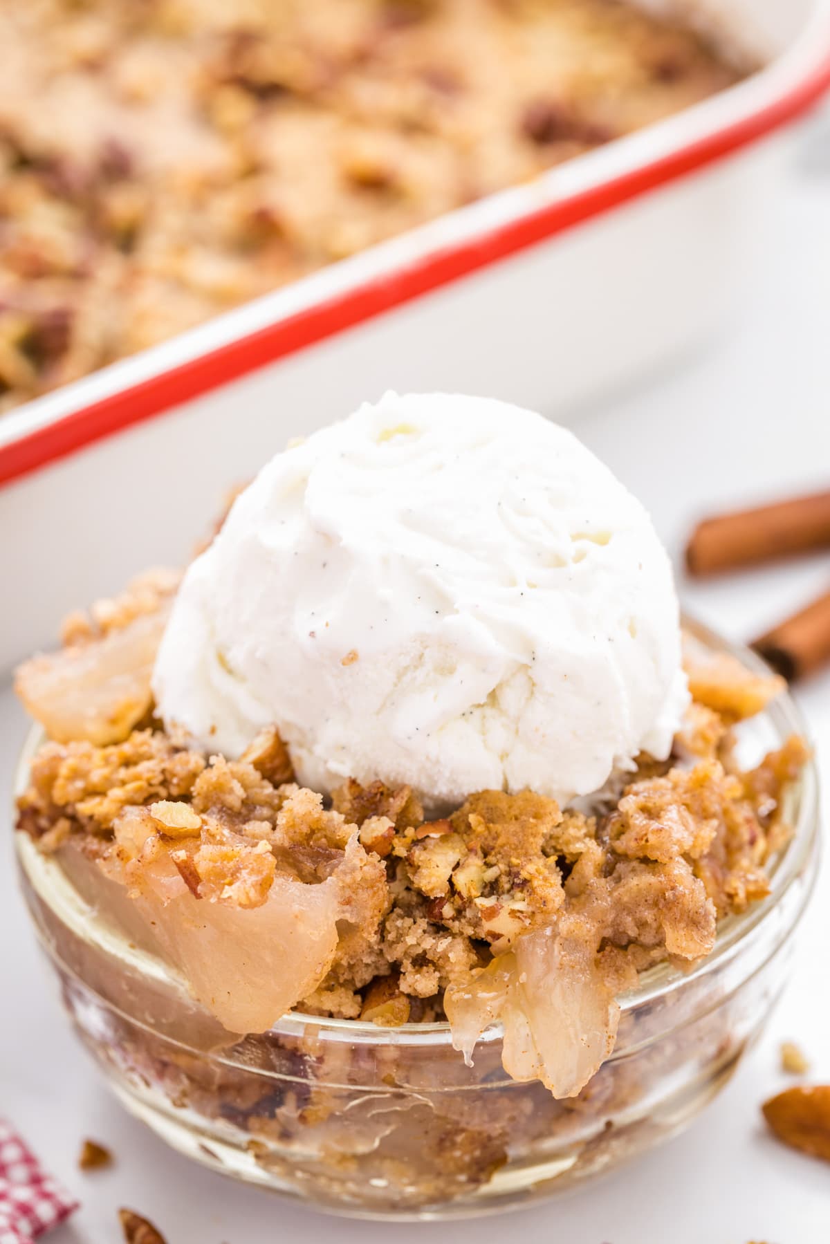 Apple Dump cake served in a bowl and topped with vanilla ice cream.