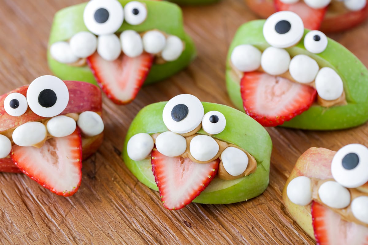 Apple Monster teeth with strawberry tongues on a wooden table.