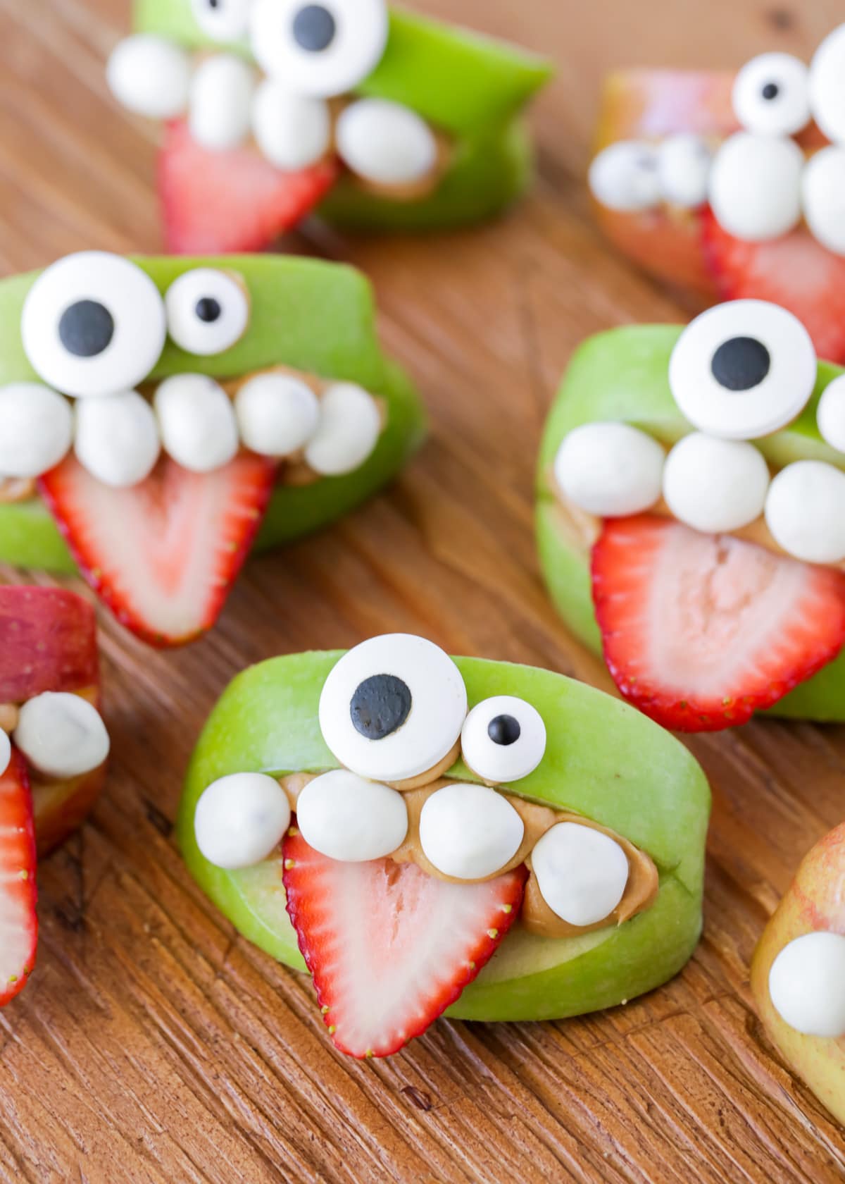 A close up of several apple monster teeth with strawberry tongues.