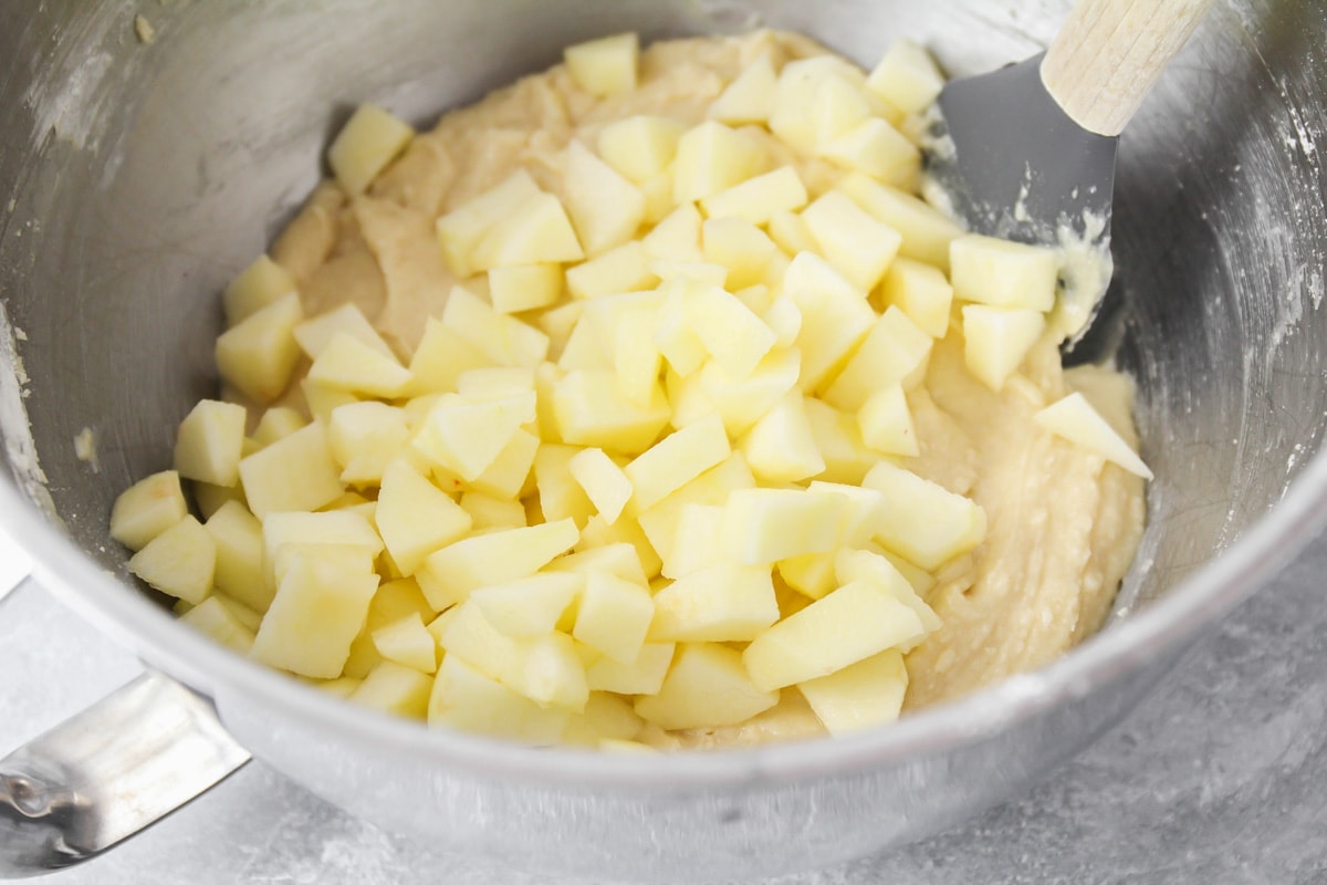 Mixing diced apples in the batter for apple muffins