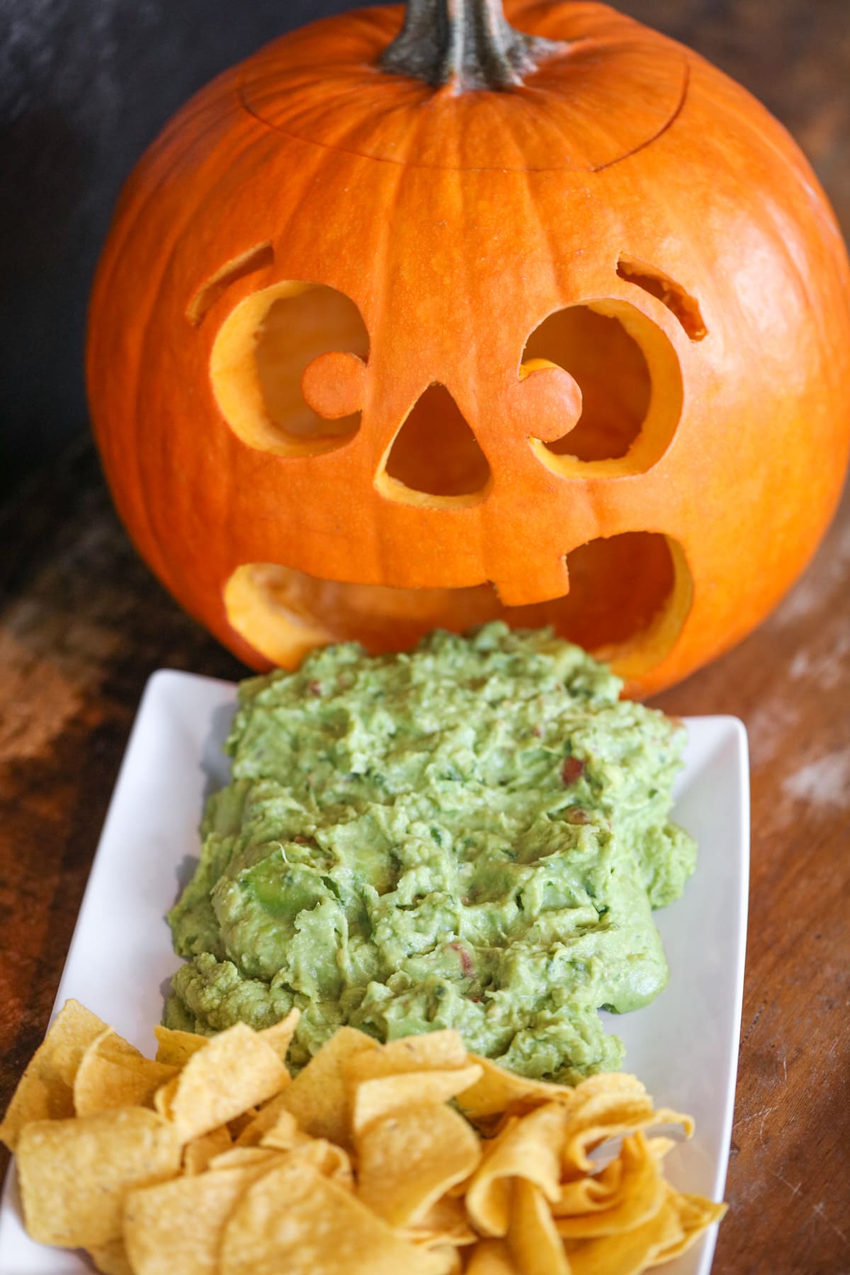 Barfing pumpkin guacamole on a white platter.