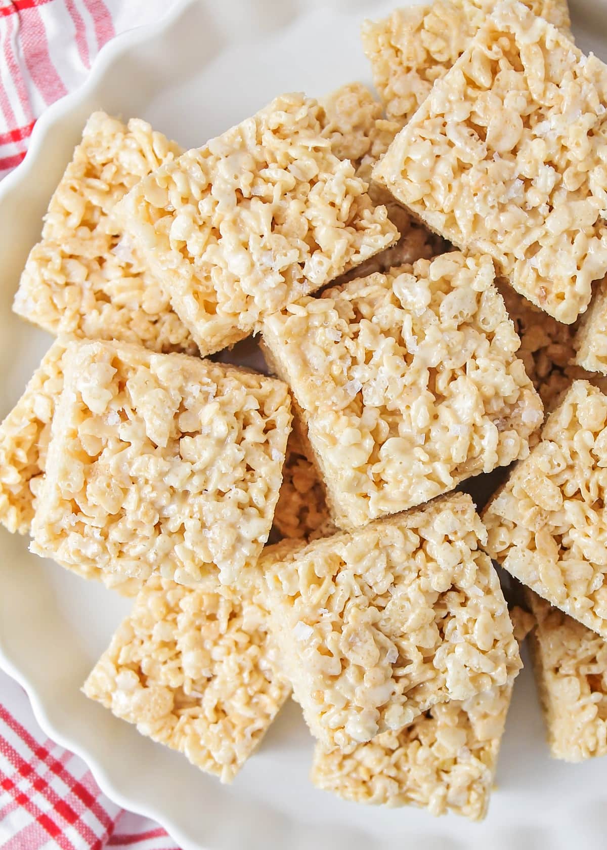 Squares of browned butter rice krispie treats on a white platter.