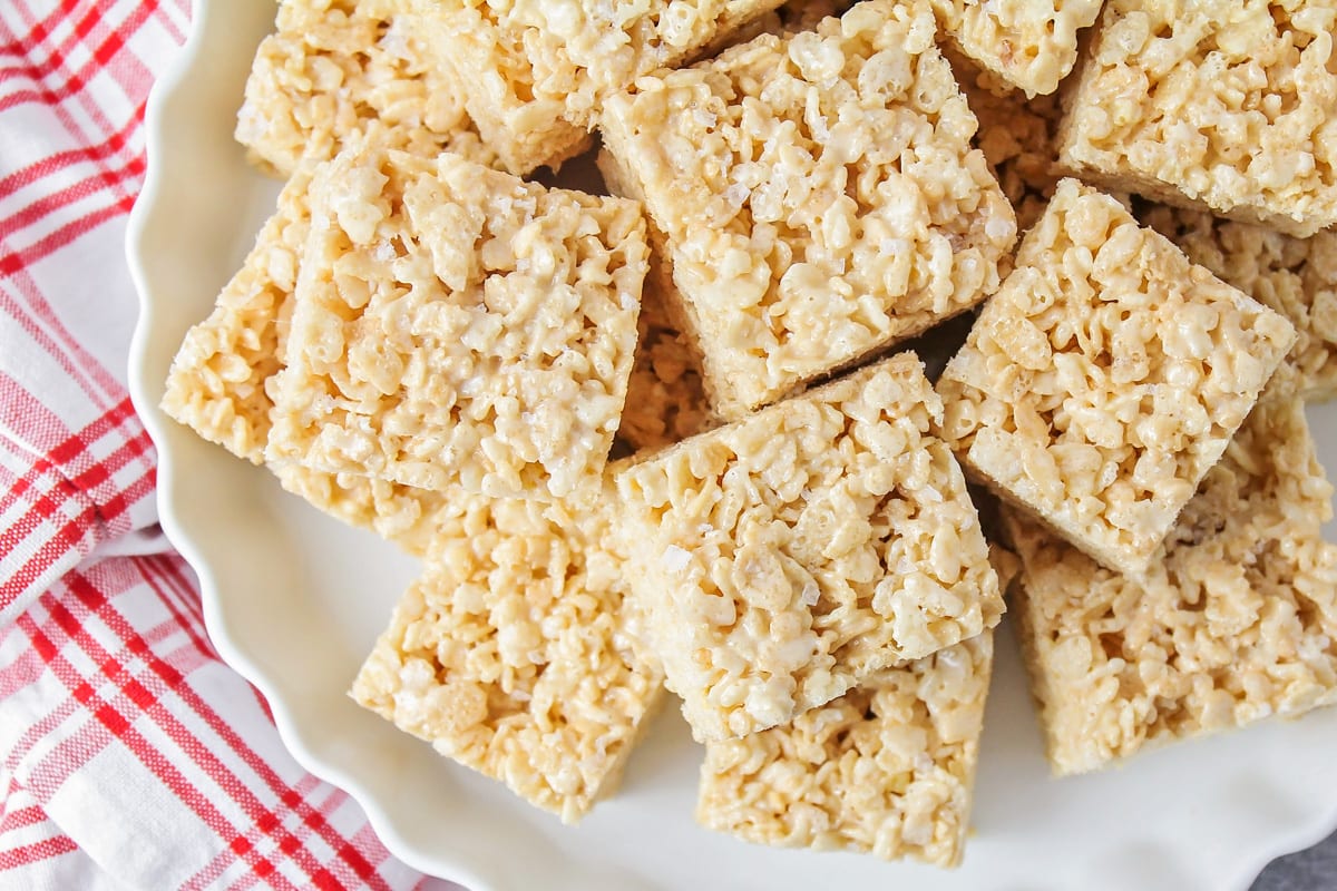 Squares of browned butter rice krispie treats on a white platter.