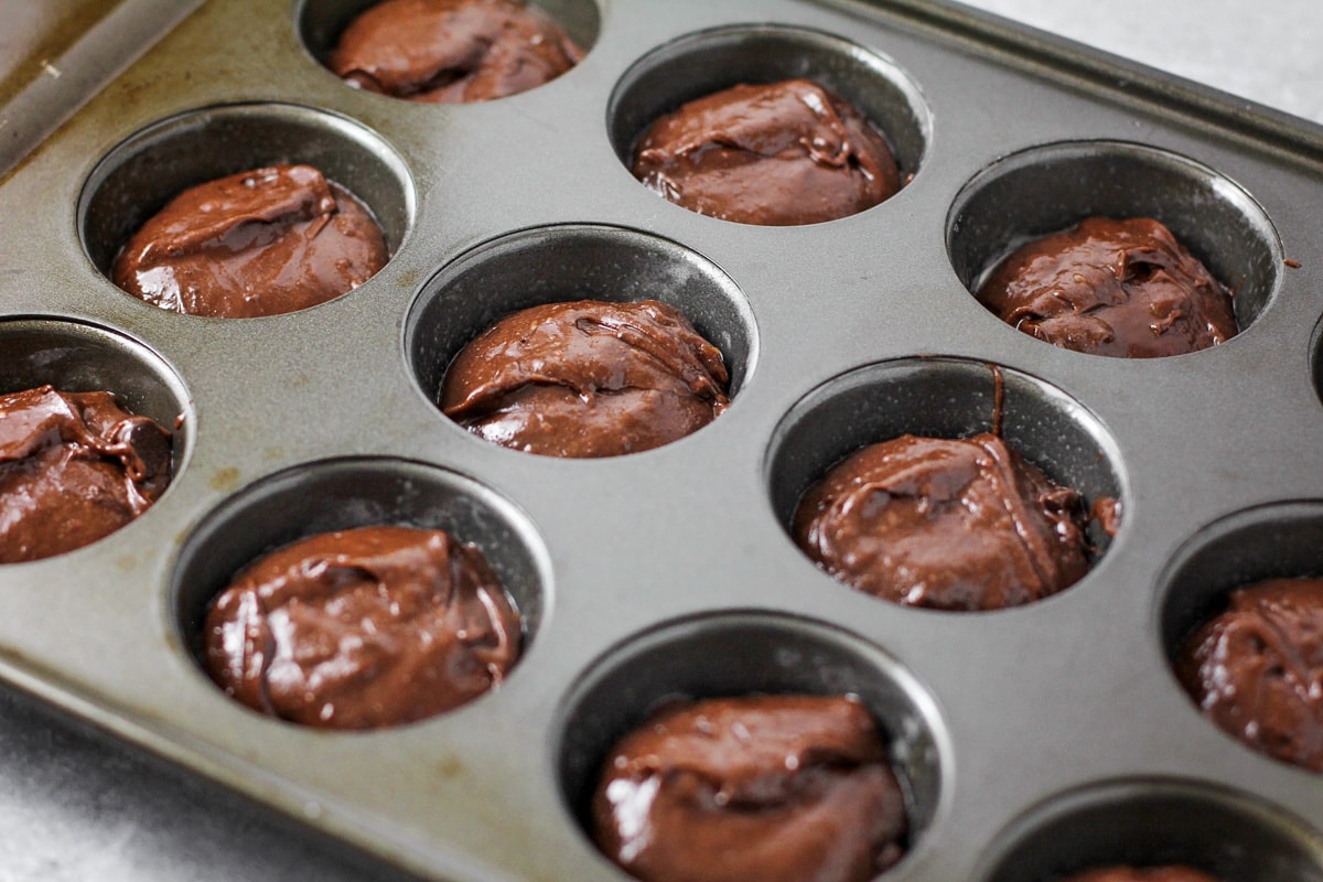 Brownie bites batter in a muffin tin ready for baking.