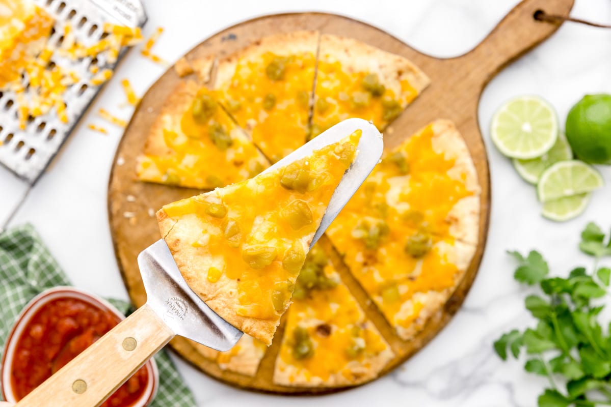SLiced cheese crisp topped with green chili
