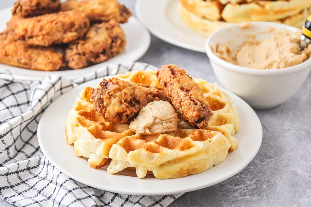 Chicken and waffles on a white plate.