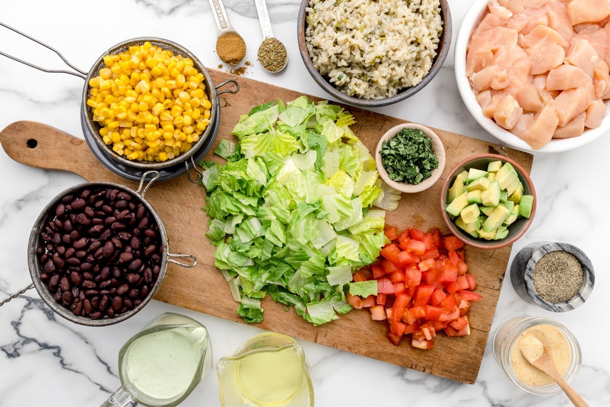 Chicken burrito bowl ingredients in bowls and on a cutting board.