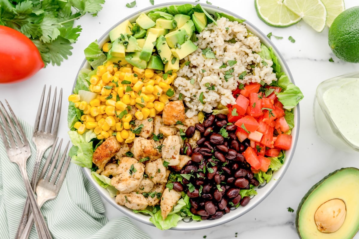 Chicken burrito bowl topped with fresh ingredients.
