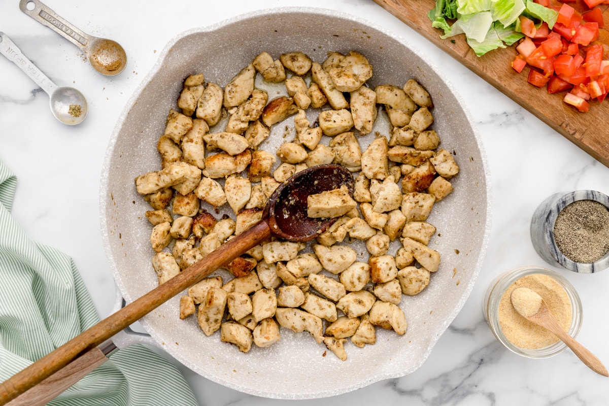 Seasoning chicken for the chicken burrito bowl.