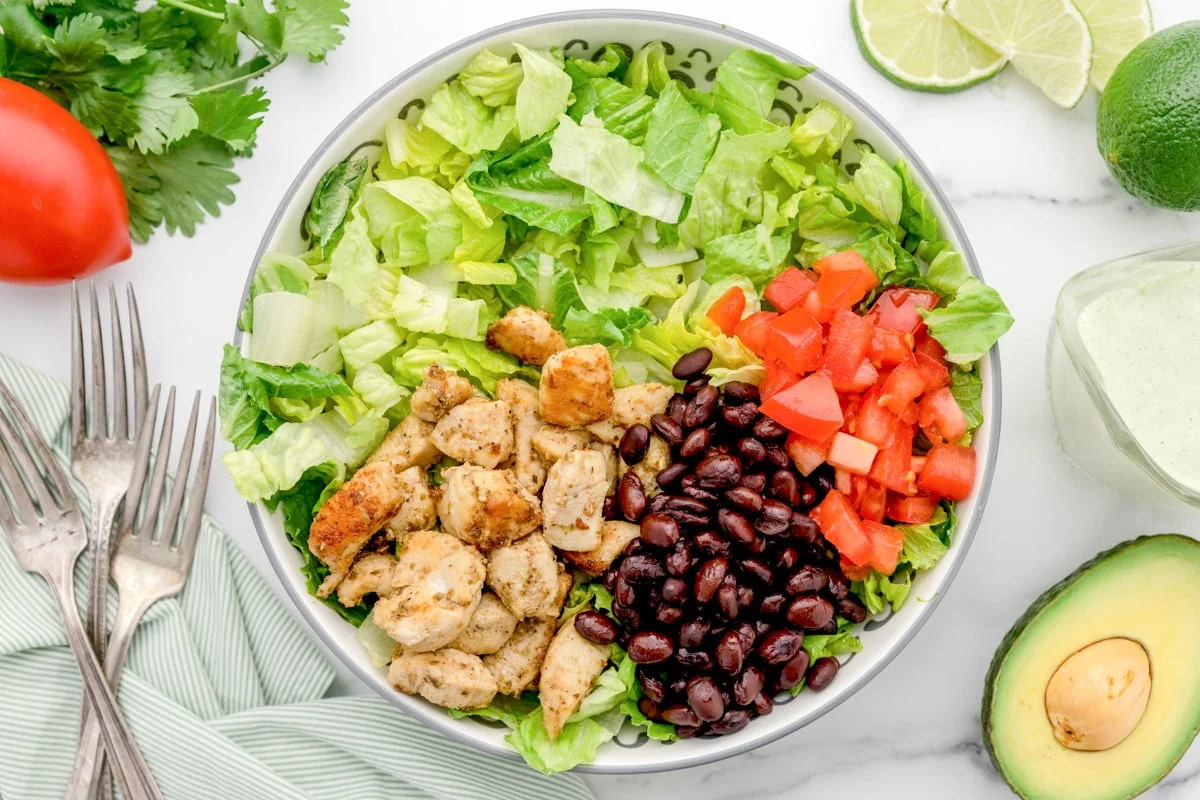 Assembling a chicken burrito bowl image.