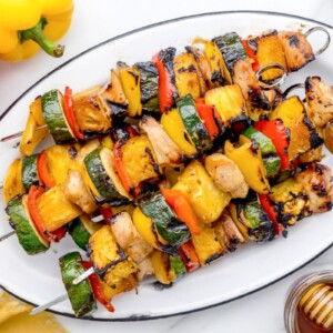 A platter of colorful grilled chicken kabobs.