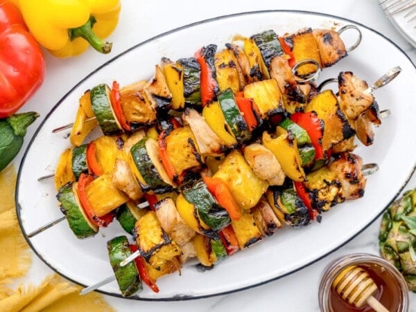 A platter of colorful grilled chicken kabobs.