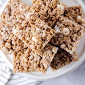 A white patter stacked with chocolate rice krispie treats.