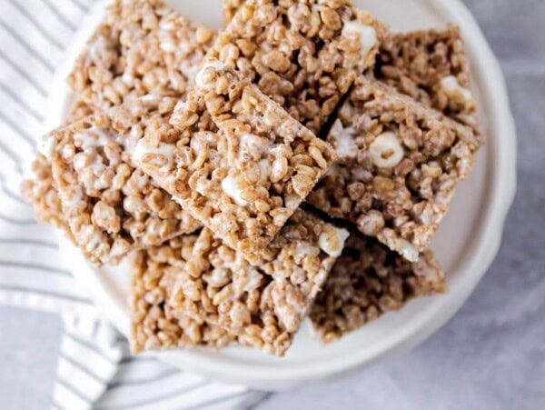 A white patter stacked with chocolate rice krispie treats.