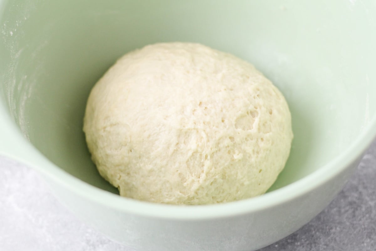 A ball of dough in a mint bowl.