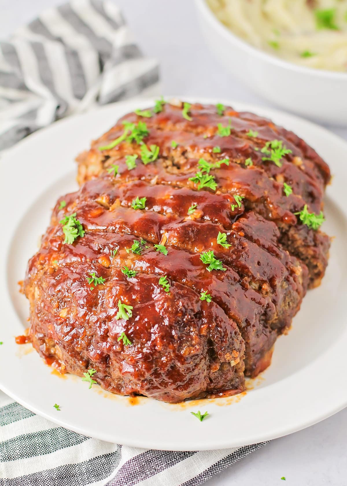 Glazed meatloaf sliced and served on a white platter