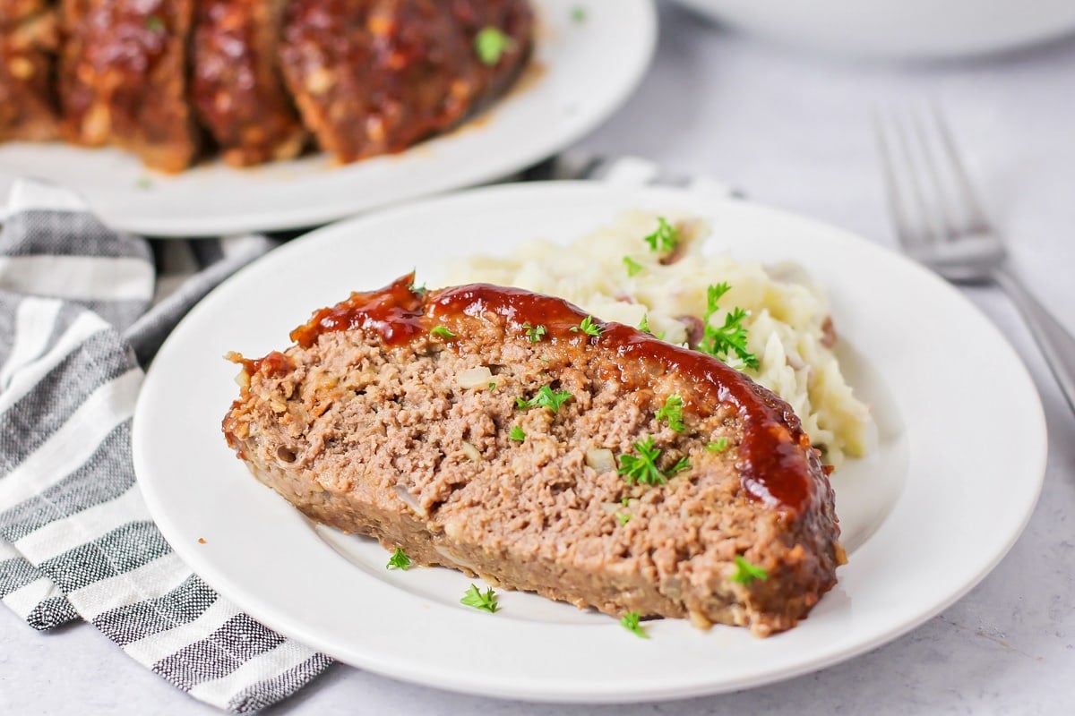 Easy Dinner Ideas - A slice of easy meatloaf on a plate with mashed potatoes.