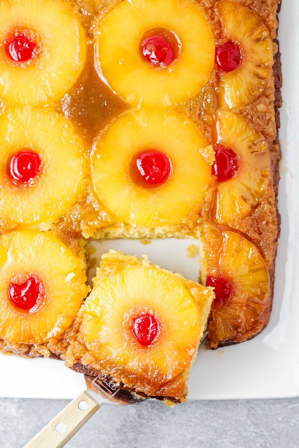 Caramelized pineapple upside down cake served in a baking dish.