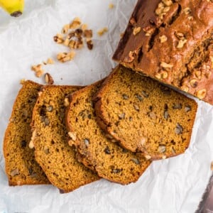Sliced pumpkin banana bread on parchment paper.