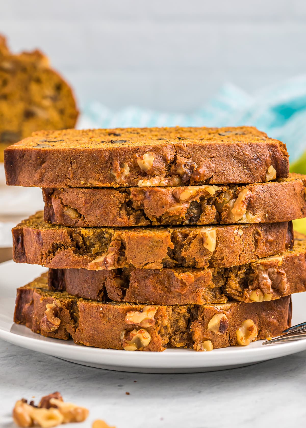 Stacked slices of pumpkin banana bread on a white plate.