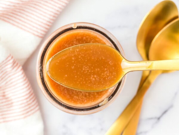 Homemade caramel sauce in a spoon.