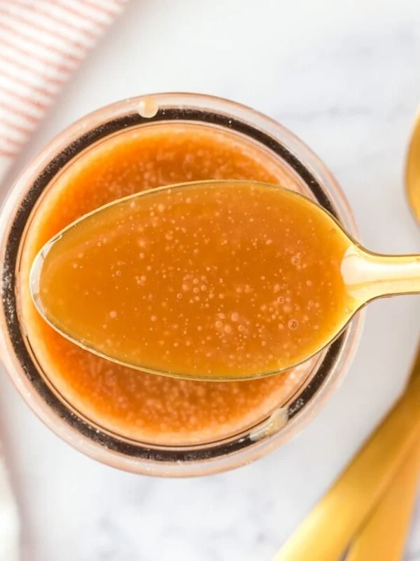 Homemade caramel sauce in a spoon.