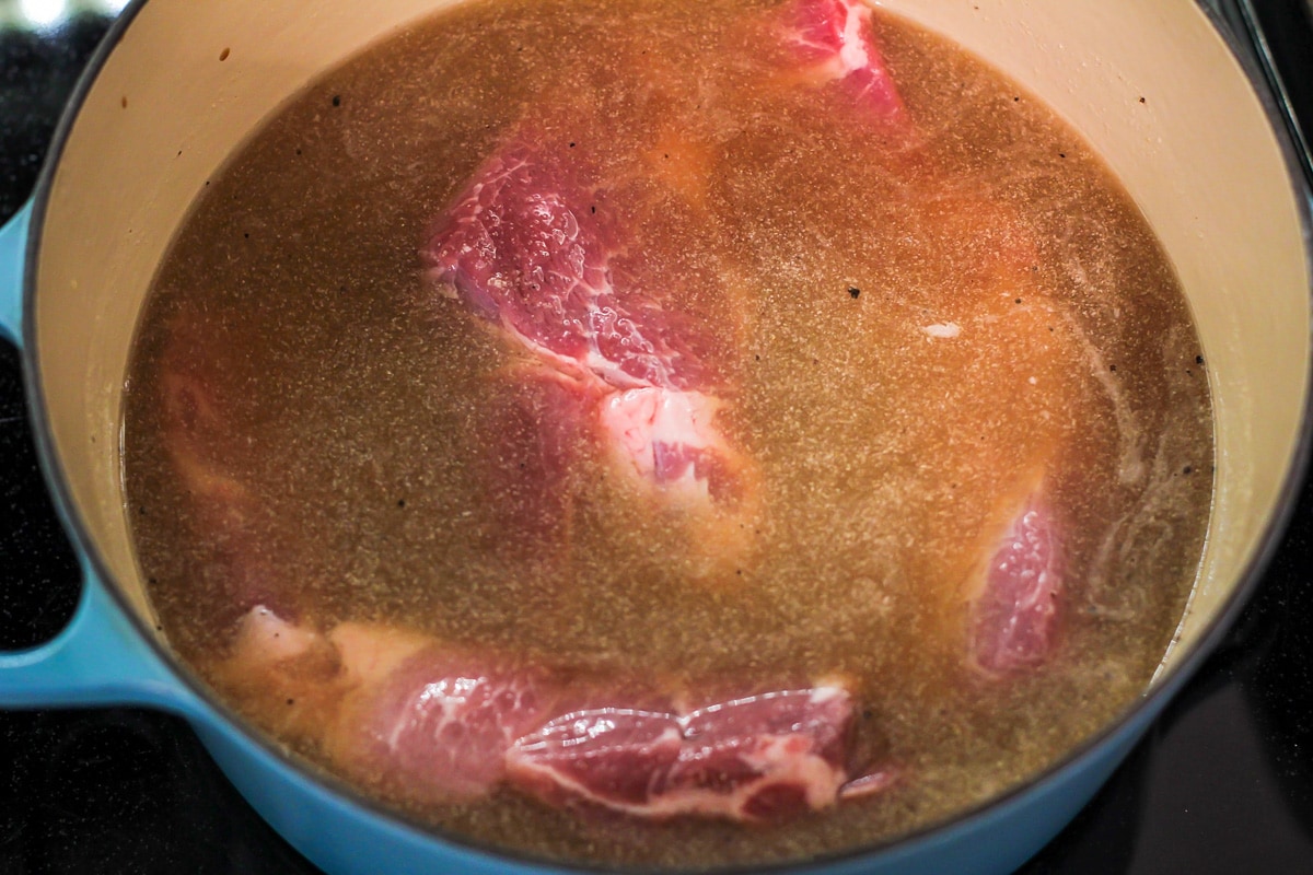 Boiling country style ribs in a dutch oven on the stove.