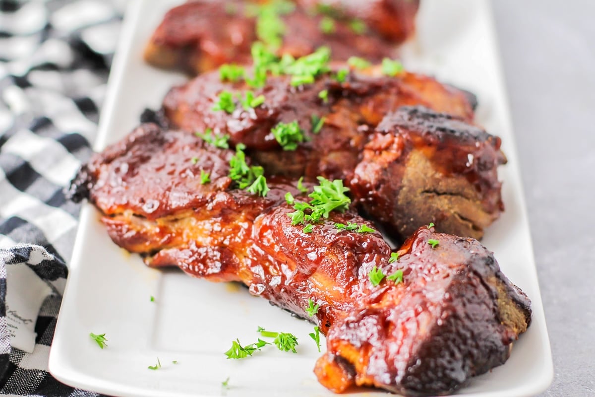 Country style pork ribs served on a white platter.