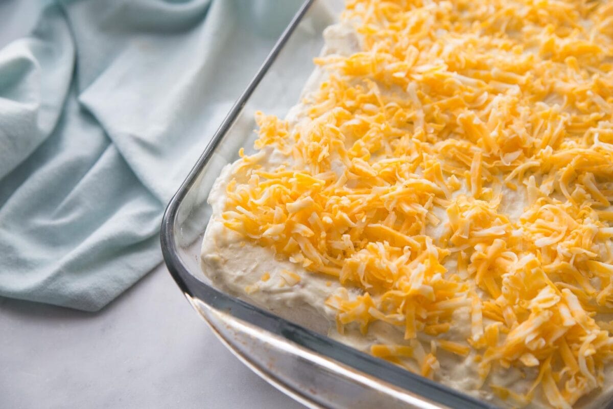 Shredded cheese on top of creamy enchiladas.