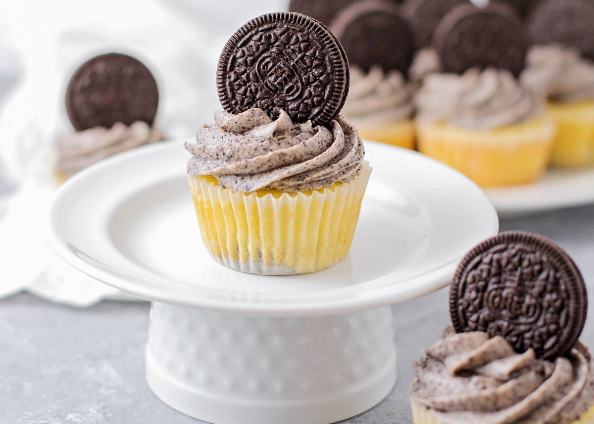 Cookies and cream cupcake topped with an Oreo on a white platter.